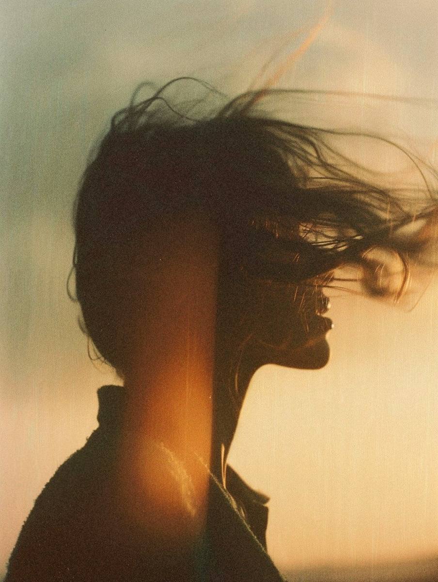 Silhouet met wapperend haar in gouden avondlicht - empowering your authentic beauty
